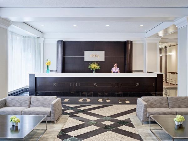 The inside of the Chelsea Hotel reception, with a friendly staff member at the desk