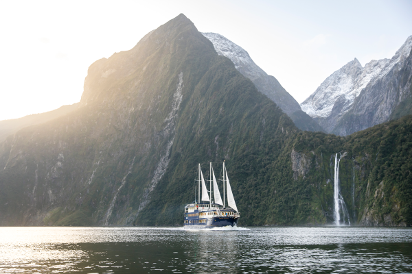 Scenic view of Milford Sound surrounded by dramatic mountains and waterfalls in New Zealand.
