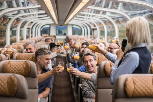 Guests onboard the Rocky Mountaineer enjoying breakfast and raising a toast in the glass dome carriage.
